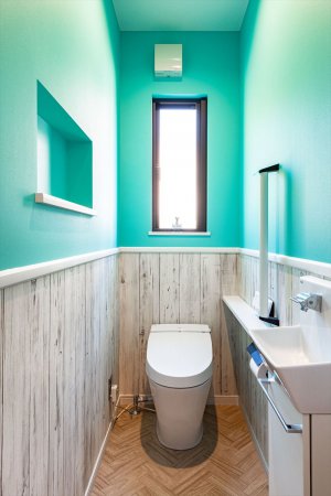 1階のトイレは海を連想させるようなブルーと木目の壁紙が印象的である。ヘリンボーンで統一感がある。