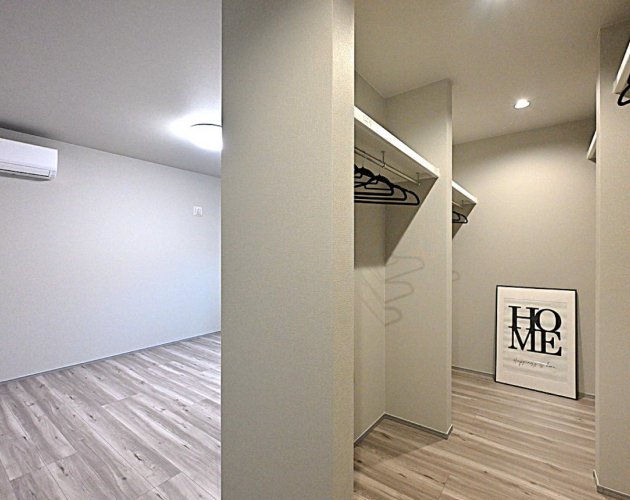 オープンなウォークインクローゼットのある、落ち着いた主寝室