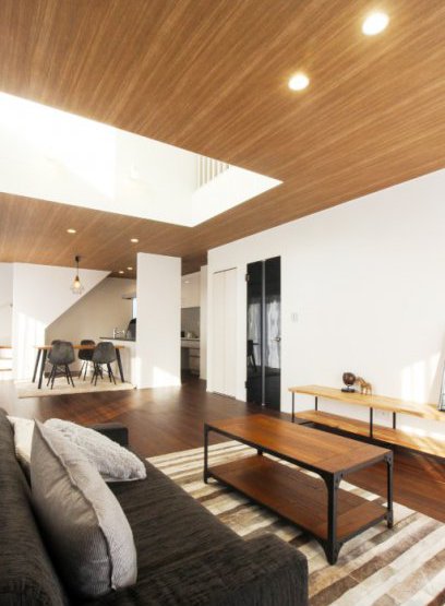 リビング中央の吹抜けと木目調の天井が特徴的