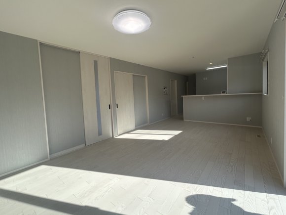 ∼広々とした開放感あふれるLDK∼
22帖の広々としたLDKは、ご家族みんながゆったりとくつろげる、開放感たっぷりの空間。
グレートーンのメインクロスに、アクセントとしてホワイトをプラス。天井とフロアもホワイトで統一し、明るく清潔感のある印象に仕上げました。

キッチンからはLDK全体が見渡せるので、お料理をしながら家族の様子を見守れるのも嬉しいポイント。
リビングを中心に各部屋へつながる間取りで、日々の暮らしがスムーズに。すべてがワンフロアで完結する設計だから、移動もラクラク。どの世代にも暮らしやすい住まいです。

※写真はイメージです。