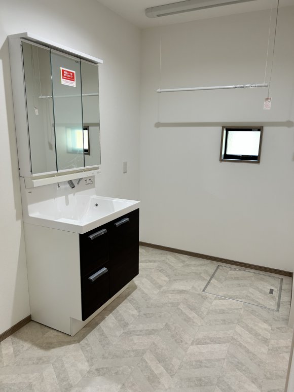 ∼ゆとりと実用性を兼ね備えた脱衣スペース∼

毎日使う脱衣室は、広さと使いやすさにこだわった3帖のゆとり空間。
朝の身支度やお風呂上がりも快適に過ごせます。
室内干しができる「ホシ姫サマ」を設置し、雨の日も安心。シンプルな家事動線で暮らしがスムーズに。
洗面化粧台はお手入れ簡単なハイバックタイプで、収納棚も置けるため整理整頓もラクに行えます。