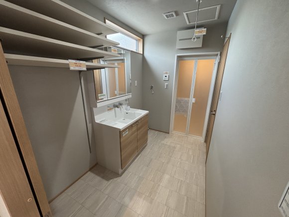 キッチンと洗面・ランドリースペースは横移動でつながる回遊動線。引き戸を採用しているため、手に物を持っていてもスムーズに移動でき、開閉のストレスがありません。玄関ホールからもキッチン横からも脱衣室へアクセスでき、家事動線が快適です。洗面脱衣室は3帖の広さを確保しており、室内干しも可能。さらに可動棚を設け、収納力にも優れた使いやすい空間になっています。

※写真はイメージです。