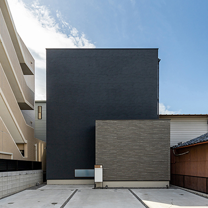 黒の塗り壁が印象的な家