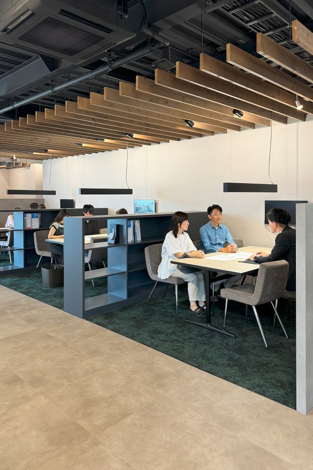 通路と打合せスペースの床を貼り分け、緩やかに空間を分けました。落ち着いた色味の絨毯で上質さを演出しています。