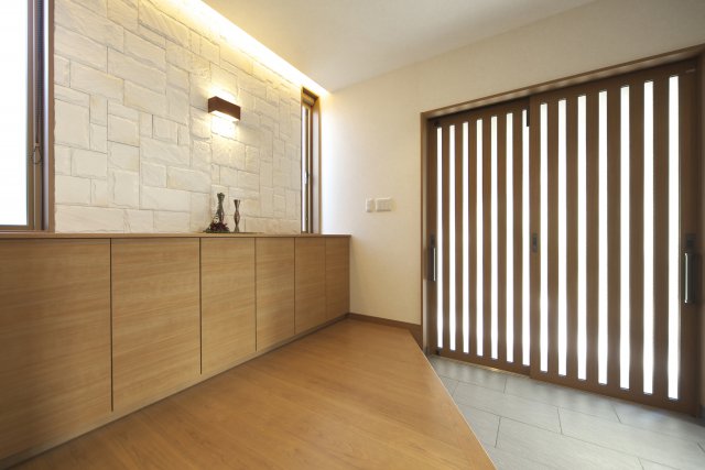 広く開放的な玄関。間接照明とタイルでおもてなしの気持ちを表現しています。