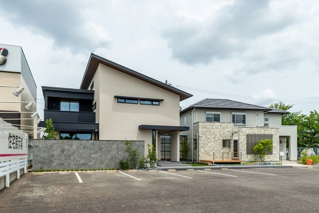 方流れ屋根に外壁をサイディング+ガルバリウムでまとめた西棟。石目調のアクセントウォールも特徴です。
東棟はグレー系のタイルにアクセントを使用した落ち着いた雰囲気の外観です。