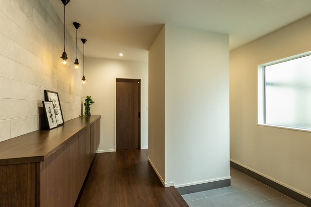 【西棟】高級感あるタイル貼りの壁面に、フロートタイプの収納を合わせたラグジュアリーな玄関ホール。