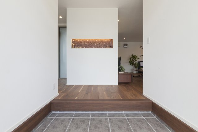 東棟の玄関ホールには横長の飾り棚を設けました。
間接照明を組み込むことで、空間を柔らかく彩ります。