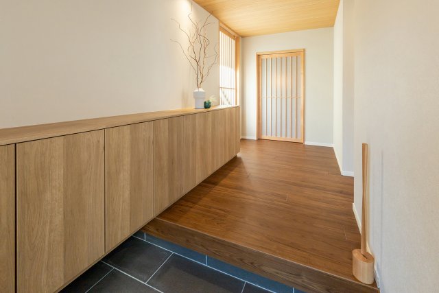 天井を下げ羽目板を貼ることで落ち着いた雰囲気の玄関。奥行きのある開放空間で来客された際の印象も良くなります。