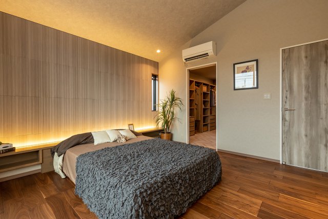 勾配天井とエコカラット、間接照明などで落ち着いた雰囲気のラグジュアリーな主寝室。ウォークイン・クローゼットを併設しているので、衣服をはじめバッグなどの小物類がたっぷり収納できるのも魅力です。