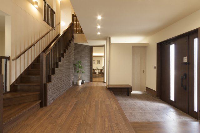 家族を迎える玄関ホールは、ゆったり広々とした空間。
クリ棒手摺の階段が、さらに視覚的な広がりを感じさせます。