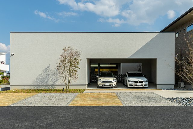 大きくスクエアに開いた印象的なファサードの先に、インナーガレージと中庭が続く外観が特徴的なデザイナーズハウス。