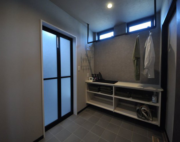ブラックトーンでデザインされた脱衣室は収納棚兼カウンターつき。干す畳む片づける…が1カ所で完結します。アイロン作業も楽々です。