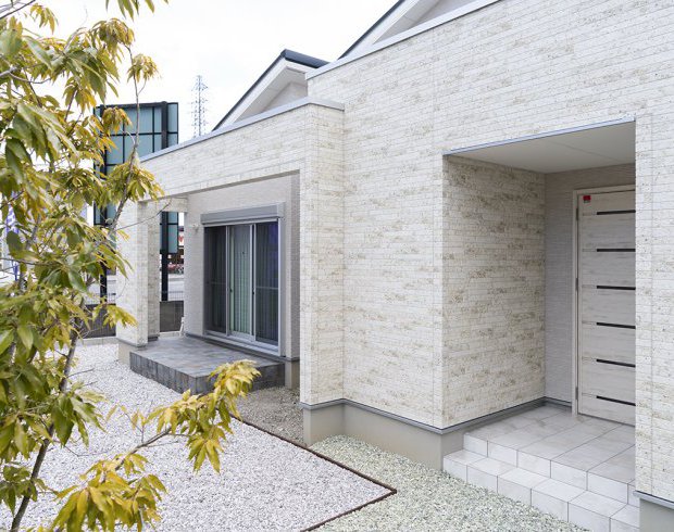 白を基調とした外壁が上品な印象を与える外観。奥にはテラスがあり、アウトドアチェアやキャンプ用品を置いて、自宅で気軽にアウトドア気分を楽しめます。