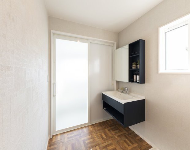 明るく開放感のある洗面スペース。白とネイビーのコントラストが空間を引き締め、朝の支度も気持ちよくスタートできます。