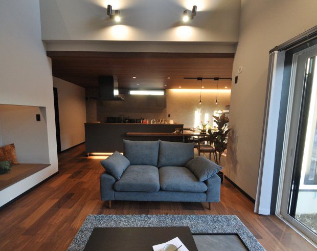 ウォールナット色で統一されたLDK。階段下は畳敷のヌックスペースに。