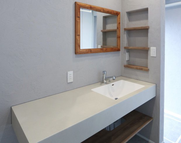 洗面室には、ゆったりとした広さのカウンターと、木のフレームが印象的なミラーを採用。壁面ニッチの収納棚は、スキンケア用品やタオルを美しく整理でき、使い勝手とデザイン性を両立しています。清潔感あふれる落ち着いた空間で、朝の支度も快適に。
※写真はイメージ。