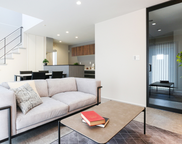 ガラス扉の透明感が際立つ、ホテルライクなモノトーンリビング。
吹抜けへと伸びる視線が、上質な開放感を生み出します。