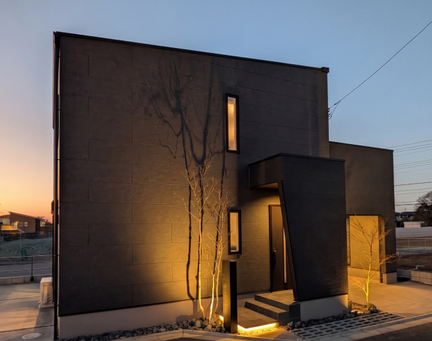 重厚感のある素材が存在感を放つモダンな外観。
日が落ちると、計算された照明が陰影を美しく際立たせ、まるでホテルのエントランスを思わせる、洗練された雰囲気が生まれます。