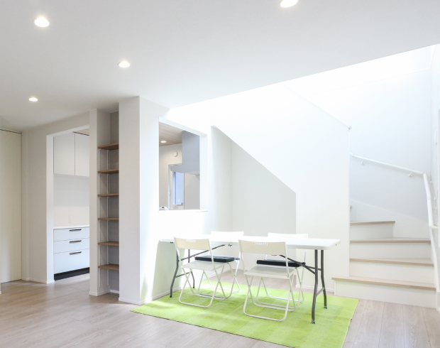 やわらかな木目の床に、白い対面システムキッチンが明るさを添えるLDK。
奥にはリビング階段を設け、空間にほどよい開放感とつながりが生まれる設計です。