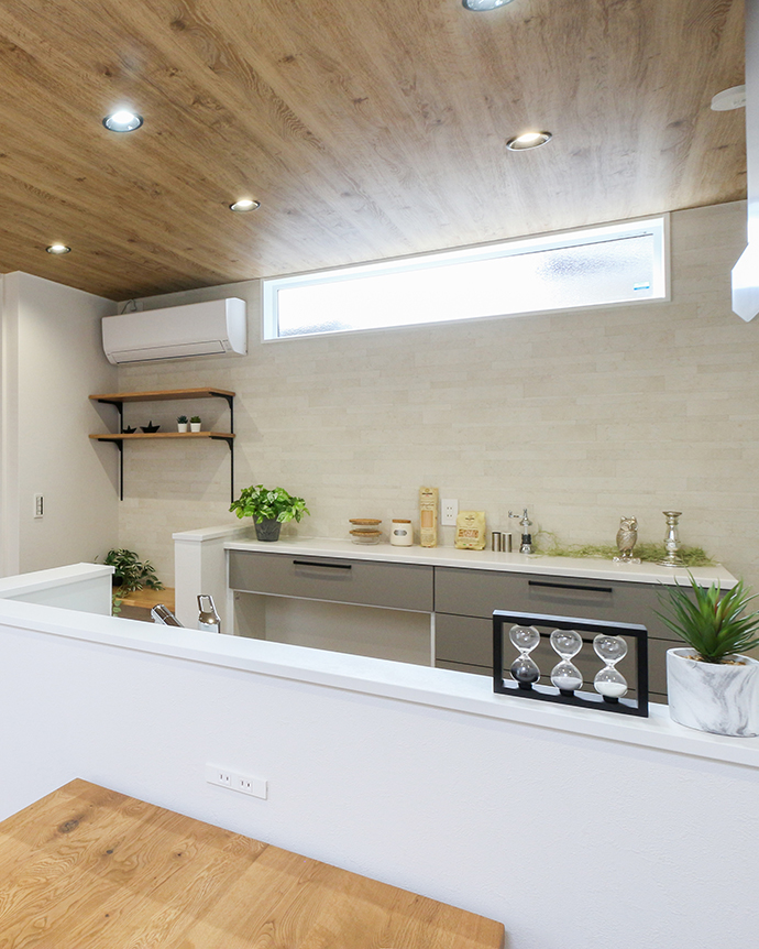 木目天井と窓のある明るい対面キッチン