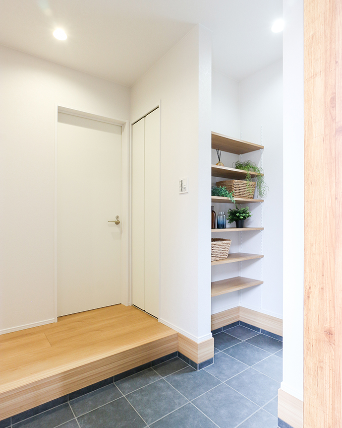 白を基調とした木の可動棚収納スペースがある玄関