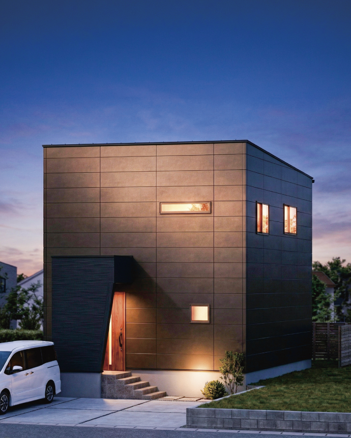 黒い外壁と温かい光が漏れるキューブ型住宅