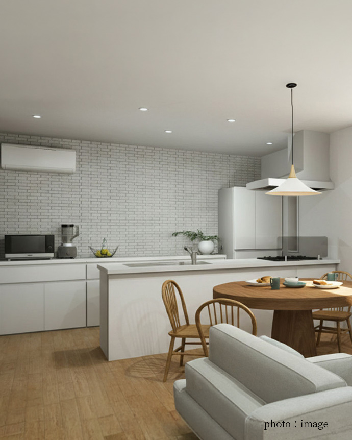 白を基調とした対面キッチンと明るいダイニング